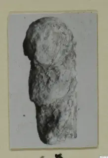 Find from Amathus: a worn, encrusted fragment of an object, photographed upright and mounted on a cream card