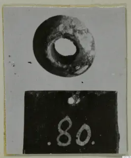 Ring-shaped stone object with a wide central hole, photographed above a number label, from Amathus