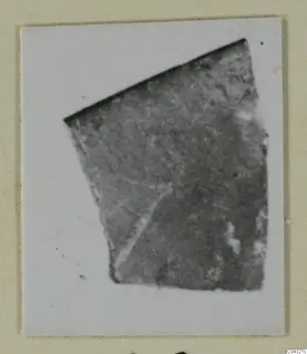 Fragment of faience from Amathus on a card mount, with a pale line running across its surface
