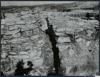 Excavation on the Idalion Acropolis with a narrow cut between layered rock faces