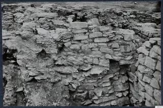 Excavated stone walls at the Idalion acropolis, with rough courses of stone and soil around them.