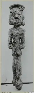 Corroded bronze figurine of a standing human figure with a wide cap or headdress