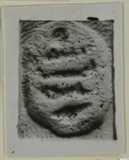 Glyptic find: a rounded stone object with horizontal bands, shown close up