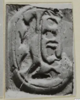 Close-up photograph of a carved seal face with a raised oval border and relief design
