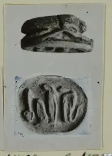 Stone scarab seal shown in side view above its engraved oval base