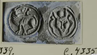 Two round seals with raised carved designs, shown side by side on a card mount