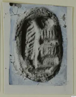 Oval glyptic object, a seal or gem from Ayia Irini, with incised lines, shown enlarged on a card mount