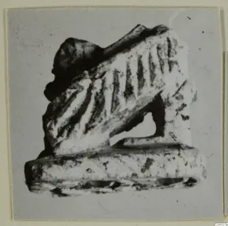 Small carved stone object with grooved sloping surface and flat base, Ayia Irini find