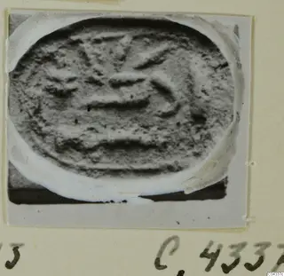 Oval seal or gem with a carved design of horizontal bands and curved strokes, pasted on an album page