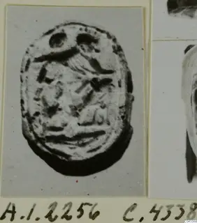 Oval seal from Ayia Irini with an incised design on its flat face, photographed on a card mount