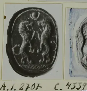 Enlarged photograph of an oval seal with carved figures, mounted on an album card