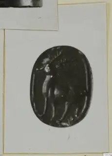Oval dark stone gem with an engraved figure in profile, shown in a print pasted on a card mount