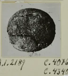 Glyptic find from Ayia Irini: a round, dark object with a cracked, crazed surface