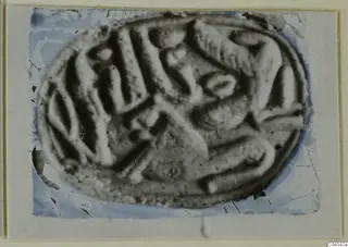 Oval stone seal or gem with carved design, photographed on a card mount