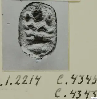 Seal or gem from Ayia Irini with a raised carved design of a face-like pattern.