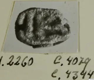 Small oval stone seal with incised markings, photographed on a mount from Ayia Irini
