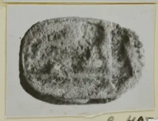 Oval stone seal or gem, shown in a blurred photograph on a pale card mount