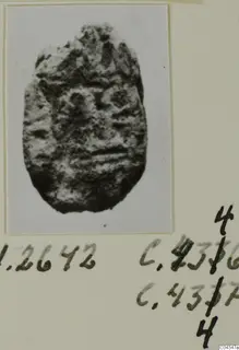 Oval stone seal or gem with a worn, uneven surface and faint raised markings.
