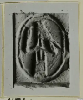 Oval seal or gem face with a raised central motif, photographed on a mounted card