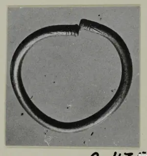 Open silver circlet with its two ends overlapping at the top, photographed against a grey background