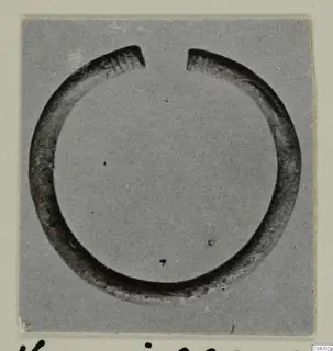 Open silver bracelet from Vouni, shown in close view on a grey card mount