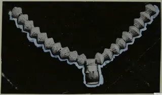 Necklace of ribbed beads with a central pendant, from Arsos, shown against a black background