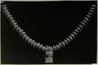 Necklace of linked cone-shaped beads with a cylindrical pendant, from Arsos
