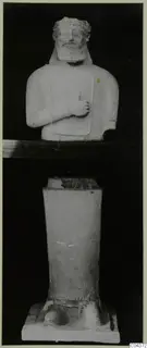 Parts of a stone statue: a bearded bust with its hand raised to the chest, shown above a separate tapering pedestal