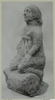 Stone statue of a kneeling female figure from Soli, head turned to the side, hair pulled back.