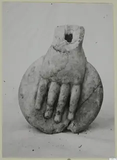 Marble sculpture fragment of a hand with curled fingers resting on a round disc-shaped piece