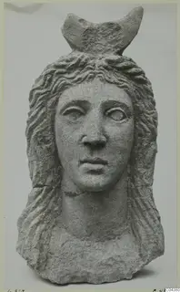 Carved grey stone head and upper bust from Soli, with wavy hair and a crescent-shaped element on the crown.