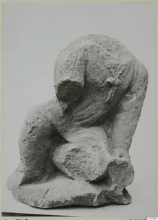 Stone sculpture from Soli: a headless, crouching draped figure carved from pale, pitted stone.
