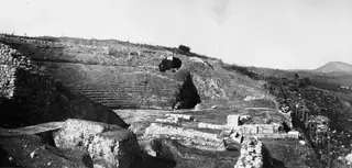The theatre at Soli, viewed from the east, with tiered stone seating cut into a hillside and excavated walls.