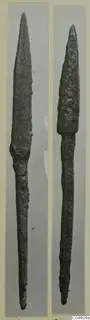 Two bronze spearheads with long tangs, photographed side by side on grey mounts.