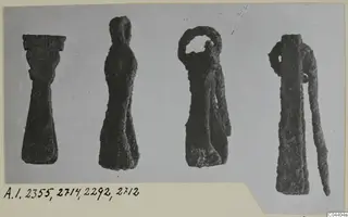 Four corroded bronze toilet-requisites from Amathus tombs, shown side by side on a mounted card