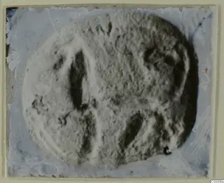 Blurred photograph of an oval engraved seal or gem with dark incised lines