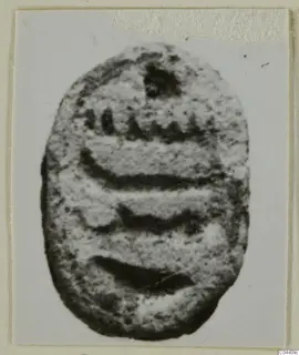 Oval stone seal with carved lines across its flat face, from Ayia Irini