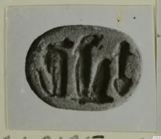 Engraved oval stone seal with a row of dark carved figures, shown on a grey card mount