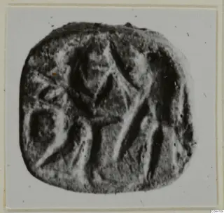 Engraved stone seal from Ayia Irini with a central figure-like design, shown on a light card mount