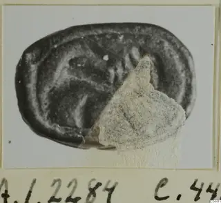 Oval seal or gem of dark stone with an engraved design, A.I.2284, mounted on a card