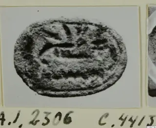 Oval engraved seal or gem with curved and straight incised lines, photographed on a mounted card
