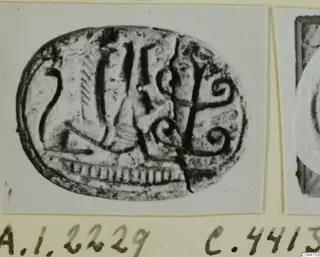 Oval engraved seal with a figure, vertical strokes and two spirals, photographed on a card mount
