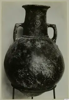 Pottery Red Polished II amphora with two handles and a rounded body, shown on a metal stand.