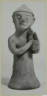 Terracotta figurine of a standing figure with a pointed cap and arms folded across the chest, from Ayia Irini