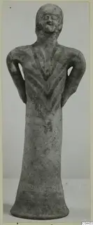 Terracotta figurine of a standing figure with arms bent at the waist and a dark painted chevron pattern on the chest