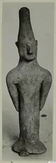 Terracotta figurine from Ayia Irini of a standing figure with a tall head and arms held at its sides
