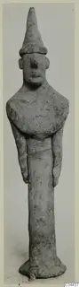 Terracotta figurine of a standing figure with a tall conical headdress and arms held close to the body