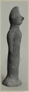 Terracotta figurine of a standing figure with a tall rounded head, narrow body and flared base