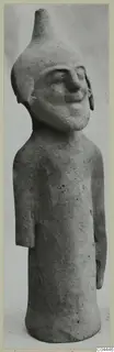 Terracotta figurine from Ayia Irini: a standing figure with a tall conical head and a broad smiling face.