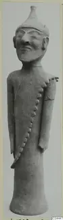 Standing terracotta figure of a man with a conical cap and a row of applied knobs running across the torso